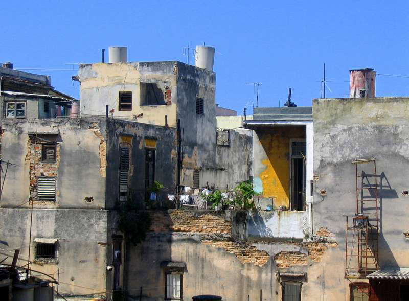 although the building is crumbling, the yellow door and laundry show it is someone's Havana home